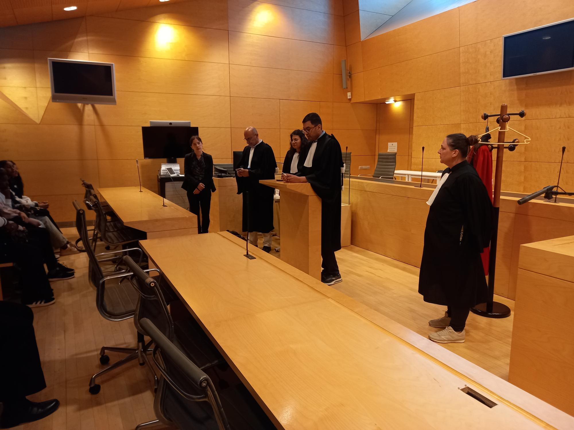 L'un des intervenants explique les fonctions d'un magistrat et le rôle de chacun lors d'un procès, tandis que les élèves prennent des notes.